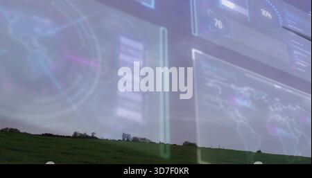 Displaying grassy hillside with low trees on horizon under overcast sky, showing HUD world map Stock Photo