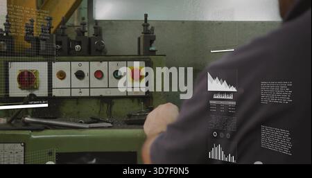 Reaching man using green machine controls in shop, in dark work shirt, red E-stop, copy space Stock Photo