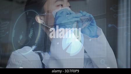 Adjusting Korean doctor in white lab coat, stethoscope and blue gloves, fitting mask in clinic HUD Stock Photo