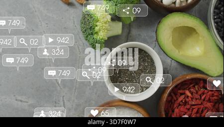Displaying white ceramic bowl of chia seeds on gray countertop, with halved avocado and overlays Stock Photo