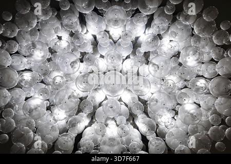 A chandelier made of a large number of white incandescent bulbs hangs from the ceiling Stock Photo