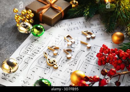 Golden music notes, sheets and Christmas decor on table, closeup Stock Photo
