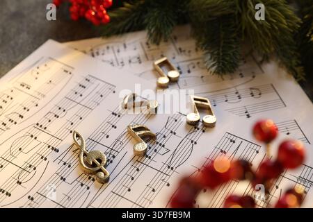 Golden music notes, sheets and Christmas decor on table, closeup Stock Photo