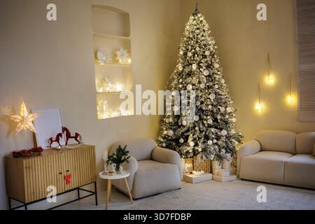 Warm festive living room with Christmas tree, fairy lights and gifts, cozy winter holiday home interior perfect as seasonal background or banner Stock Photo