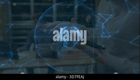 Projecting holographic globe aligning with hands and tablet in office, with staff in ribbed sweater Stock Photo
