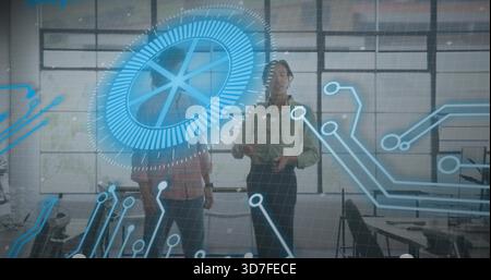 Interacting two male colleagues wearing business-casual at studio, with holographic circular HUD Stock Photo
