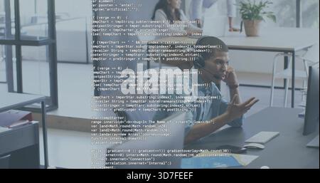 Gesturing man in button-down shirt explaining code on monitor at open office, with code overlay Stock Photo