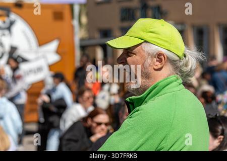 Gray-haired man with green fleece jacket and green baseball cap at World Village festival in Suvilahti district of Helsinki, Finland Stock Photo