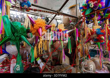 Close view of two traditional Mexican star piñatas with silver peaks, made with bright colored tissue paper, hanging for the Posadas holiday celebrati Stock Photo