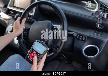 Woman using OBD2 diagnostic scanner.  Stock Photo