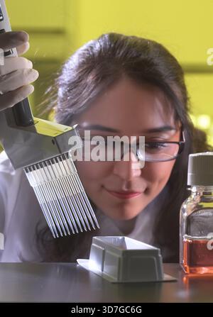 Female lab technician looking very closely as she uses multichannel in scientific laboratory, New Jersey USA Stock Photo