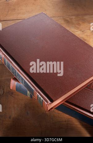 Looking down on stack offered leather bound books, USA Stock Photo