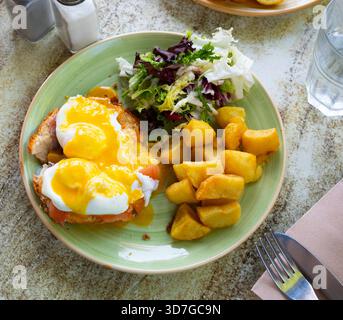 Portion of eggs benedict toast with salmon and potatoes closeup Stock Photo