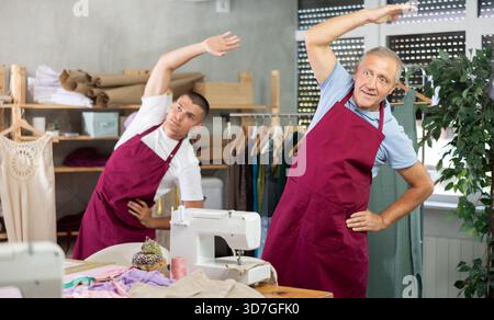 Male tailors doing a warm-up at work Stock Photo
