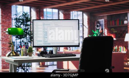 Modern loft with desktop monitor ready for coding and programming tasks, spacious workspace . Perfect environment for developing secure applications and online software systems. Stock Photo