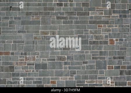 Background of grey rectangular stone wall. Random size stone wall. Stock Photo