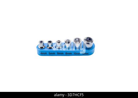 Small chrome socket and screwdriver bits arranged in blue plastic holders, isolated on a clean white background. Stock Photo