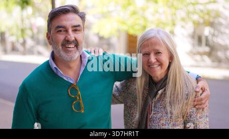 Happy senior couple embracing and smiling outdoors Stock Photo