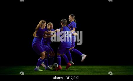 Teenage soccer team celebrating together in energetic group movement Stock Photo