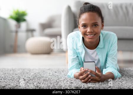 Young Afro American Lady Enjoys Funny Videos While Chatting With Friends on Her Phone Stock Photo