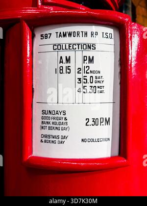 Close-up of a red British post box showing detailed mail collection times and address label on Tamworth Road in the UK Stock Photo
