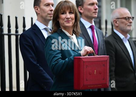 11 Downing Street, London, UK. 26th Nov, 2025. Labour Chancellor of the Exchequer Rachel Reeves MP stands outside No. 11 for the traditional press photocall holding the red despatch box containing her Budget 2025 speech to Parliament. This budget proving to be the most leaked, discussed and criticised in many years. Image: To left of Rachel Reeves is Lord Livermore, immediate right is Torsten Bell. Credit: Malcolm Park/Alamy Live News Stock Photo