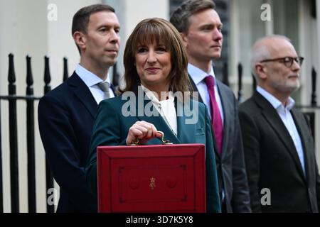 11 Downing Street, London, UK. 26th Nov, 2025. Labour Chancellor of the Exchequer Rachel Reeves MP stands outside No. 11 for the traditional press photocall holding the red despatch box containing her Budget 2025 speech to Parliament. This budget proving to be the most leaked, discussed and criticised in many years. Image: To left of Rachel Reeves is Lord Livermore, immediate right is Torsten Bell. Credit: Malcolm Park/Alamy Live News Stock Photo
