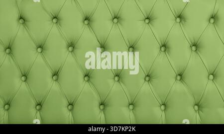 Close up background texture of pastel green capitone genuine leather, retro Chesterfield style soft tufted furniture upholstery with deep diamond pattern and buttons Stock Photo