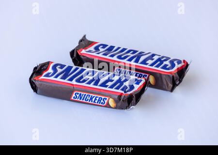 A pair of well-known Snickers chocolate bars, a signature product from Mars, Inc., featuring its unique blend of milk chocolate, nougat, caramel, and Stock Photo