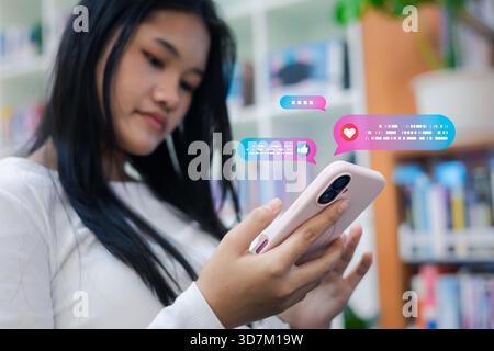 Teen girl using smartphone with colorful chat bubbles, social media messages, likes, and digital communication icons, representing online interaction Stock Photo