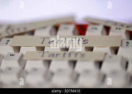 economic tariffs concept on a keyboard. close-up shot of paper strips with the word tariffs, symbolizing global trade, business, and political issues Stock Photo