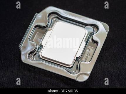 One single brand new generic blank modern desktop PC CPU processor in a protective plastic tray packaging on black background, silicon lottery concept Stock Photo