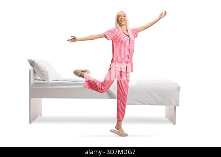 Full length shot of a young woman in pajamas dancing isolated on white background Stock Photo