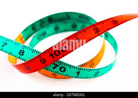 Colorful body sizes measuring tape coiled on white background, centimeter scale for tailoring, sewing and body measurement, fitness diet weight loss t Stock Photo
