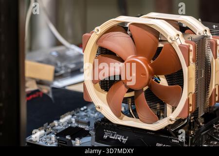A modern desktop PC motherboard with a large dual fans Noctua CPU air cooler installed, RAM modules visible, open bench computer build closeup, assemb Stock Photo
