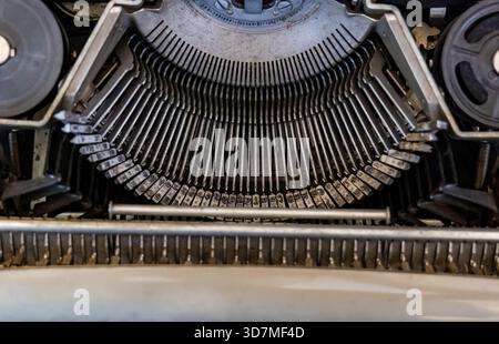 Vintage typewriter inside view, typebars, symmetrical overhead view of an old antique mechanical writing equipment, metal parts macro detail closeup, Stock Photo