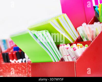 Colorful notepads and pens on a shelf in a store Stock Photo