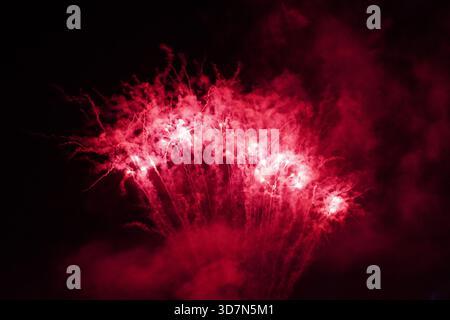 Red fireworks exploding in the night sky Stock Photo
