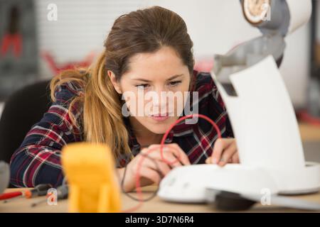 woman using multimeter to test an appliance Stock Photo
