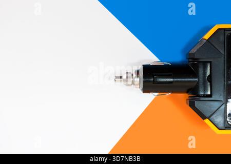 Large electric adapter for charging devices through a Car cigarette lighter plug, on colorful background. Stock Photo