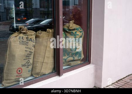 Sacks of coffee beans rest in a shop window, showcasing rich textures and city views. Kyiv, Ukraine, November 26, 2025. Stock Photo