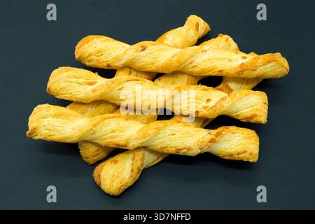 Crusty Bread Sticks or twists cooling on a slate board and ready to eat straight out of the oven. Stock Photo