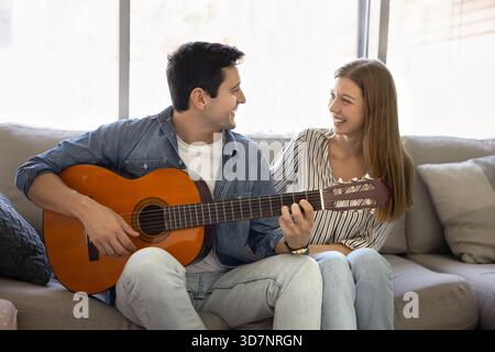 Man playing guitar for his beautiful Latina girlfriend Stock Photo