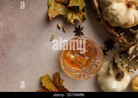 Whiskey with cinnamon, pumpkins and dried fall leaves.. Stock Photo