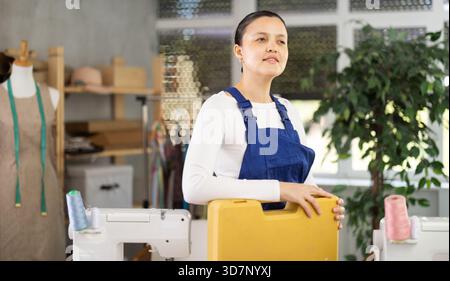 Woman sewing machine repairman standing in workshop Stock Photo