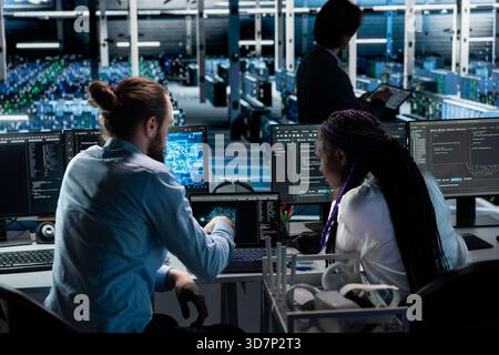 Teamworking server farm colleagues deploying AI tools to automate repetitive workflows. Team of data center engineers managing datasets used in artificial intelligence training, streamlining tasks Stock Photo