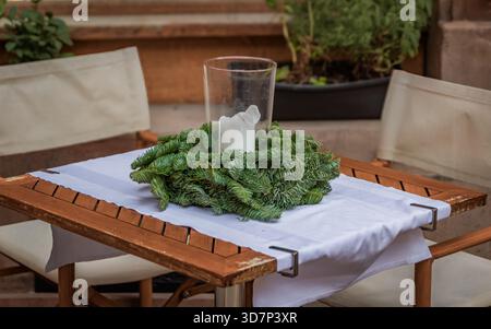 Rustic outdoor restaurant, winter wonderland tables with Christmas wreaths and candles wait for customers at Christmas time in Strasbourg, France Stock Photo