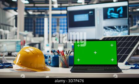 Green screen laptop used to adjust photovoltaics factory system parameters. Mockup notebook in office used for optimizing energy supply in solar panel manufacturing plant Stock Photo