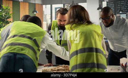 Real estate professionals using architectural software to refine housing layouts and 3D models. Development team collaborates on zoning regulations and property investment strategies. Stock Photo