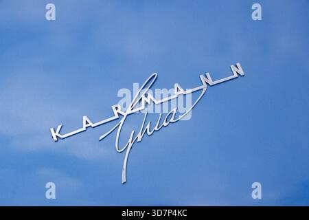 Close-up of the Karmann Ghia emblem on the exterior of a vintage Volkswagen car against a blue painted surface Stock Photo